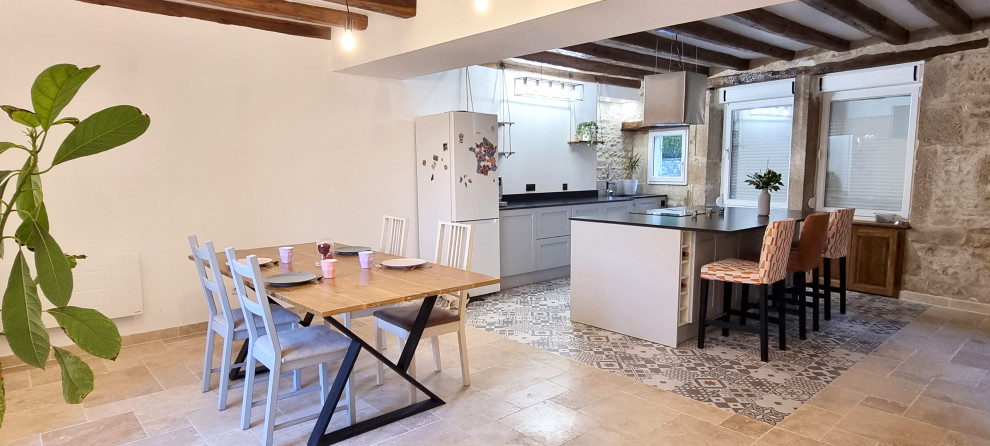 Inspiration for a large country galley open plan kitchen in Dijon with an integrated sink, granite benchtops, black splashback, granite splashback, panelled appliances, cement tiles, with island, beige floor, black benchtop and exposed beam.