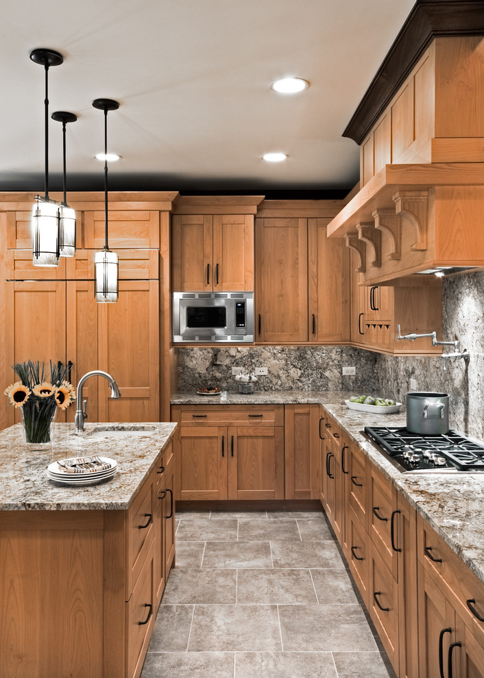 This is an example of a transitional l-shaped kitchen in Chicago with granite benchtops, shaker cabinets, stone slab splashback and panelled appliances.