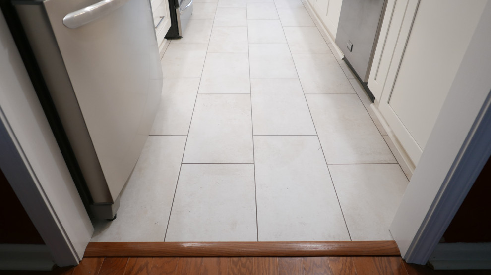 Example of a mid-sized transitional galley porcelain tile and beige floor eat-in kitchen design with an undermount sink, shaker cabinets, white cabinets, quartz countertops, brown backsplash, porcelain backsplash, stainless steel appliances, no island and white countertops