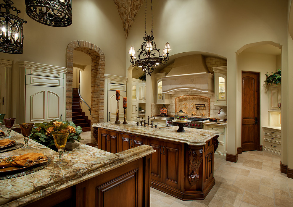 Inspiration for a huge u-shaped travertine floor open concept kitchen remodel in Phoenix with a farmhouse sink, raised-panel cabinets, medium tone wood cabinets, granite countertops, beige backsplash, subway tile backsplash, stainless steel appliances and two islands