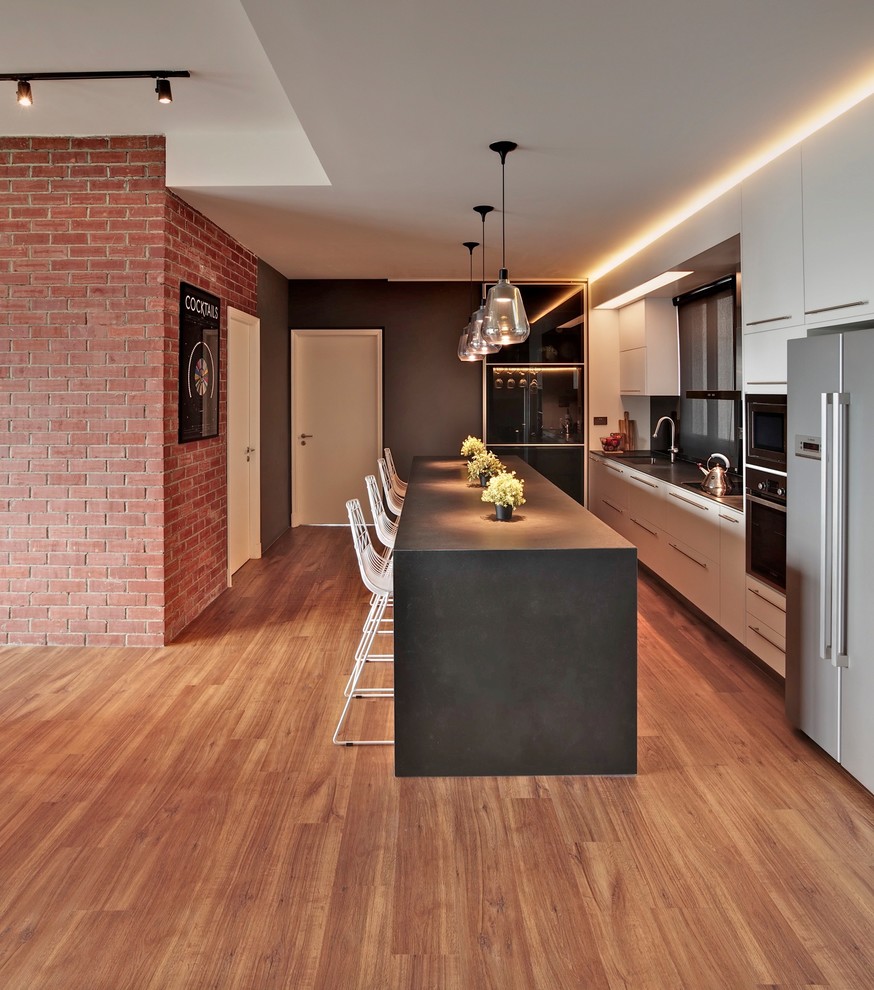 Design ideas for a transitional kitchen in Singapore with flat-panel cabinets, white cabinets, medium hardwood floors and with island.