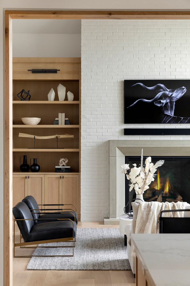 Cette photo montre un salon chic ouvert avec un mur blanc, parquet clair, une cheminée standard, un manteau de cheminée en pierre, un téléviseur fixé au mur et un plafond voûté.