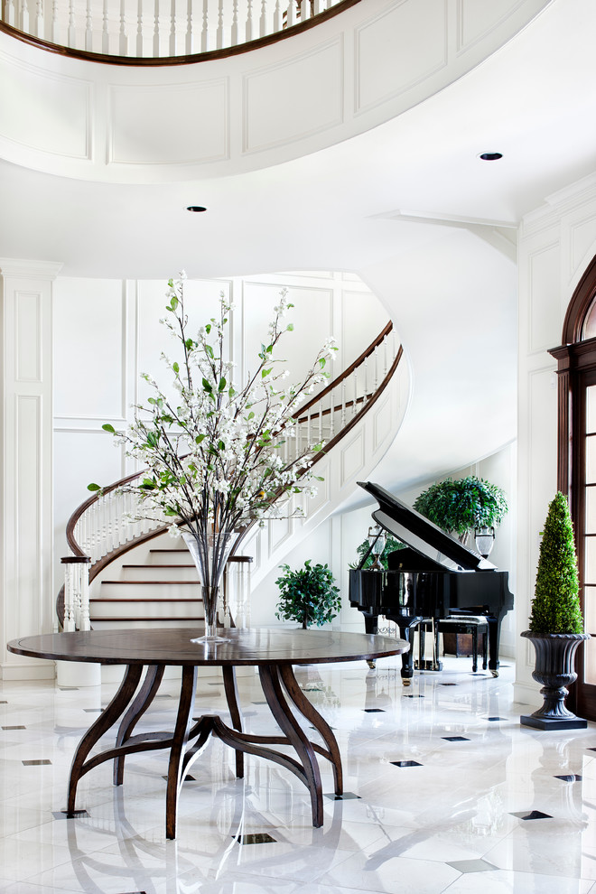 Photo of an expansive traditional foyer in Houston with white walls and white floor.