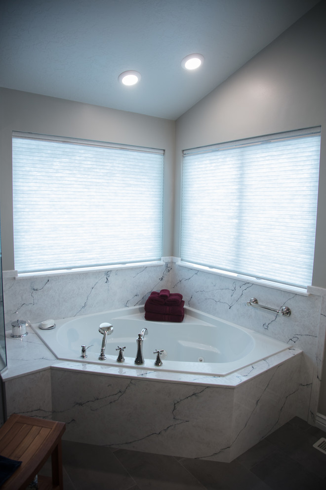 This is an example of a large contemporary master bathroom in Salt Lake City with a corner tub, a corner shower, an integrated sink, marble benchtops and a hinged shower door.