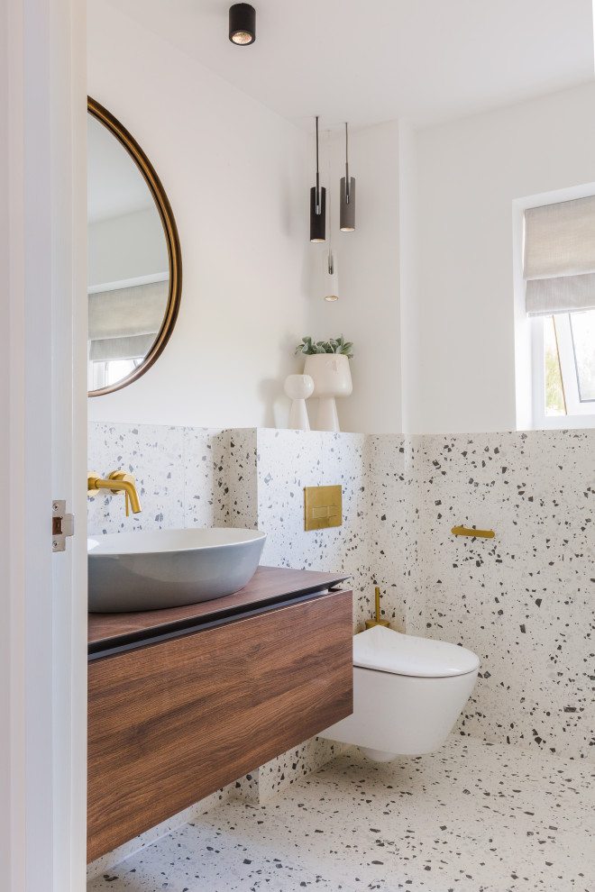 Réalisation d'un WC et toilettes design en bois brun avec un placard à porte plane, un mur blanc, un lavabo suspendu, un plan de toilette en bois, un sol blanc, un plan de toilette marron et meuble-lavabo suspendu.