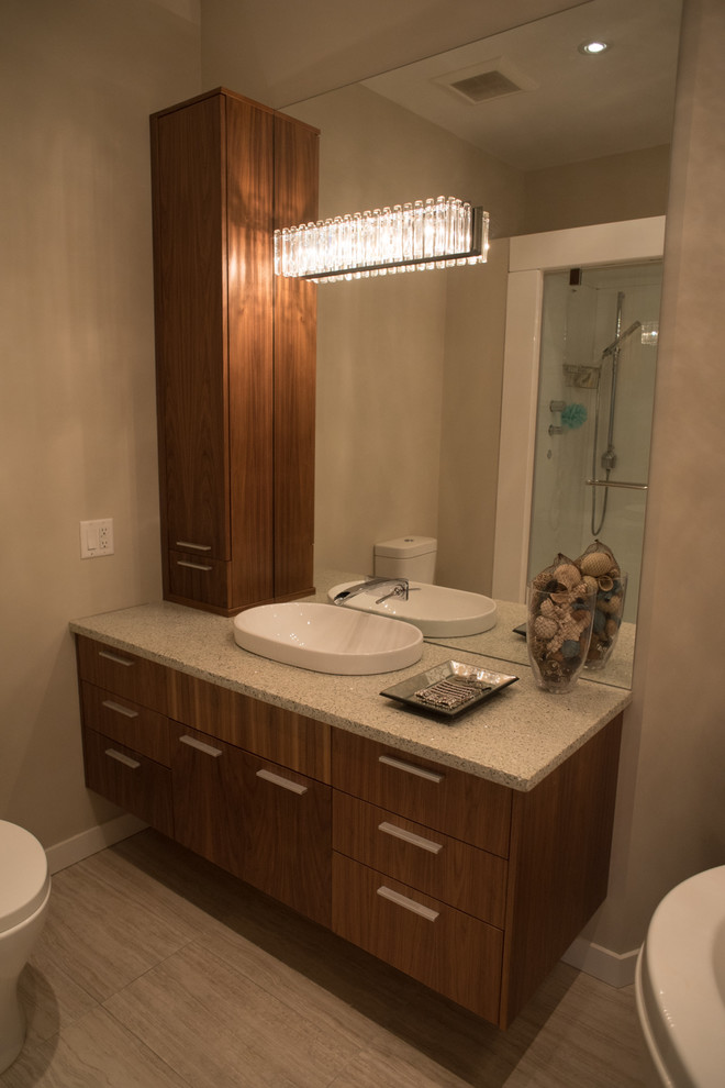 Inspiration for a mid-sized contemporary master bathroom in Vancouver with flat-panel cabinets, medium wood cabinets, recycled glass benchtops, a freestanding tub, a corner shower, a one-piece toilet, porcelain floors, a vessel sink, gray tile and porcelain tile.