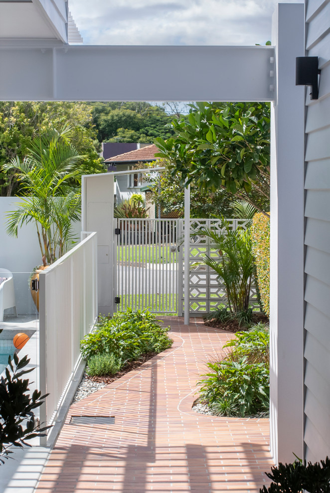 Große Moderne Haustür mit grauer Wandfarbe, Backsteinboden, Drehtür, Haustür aus Metall, rotem Boden und Holzwänden in Brisbane