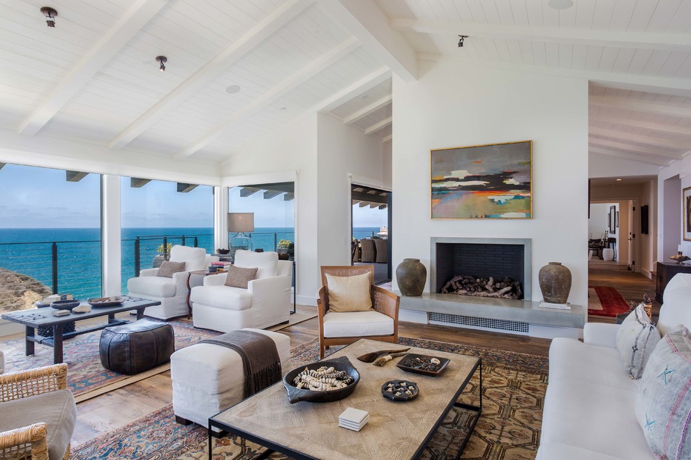 Inspiration for a beach style living room in Orange County with white walls, dark hardwood floors and a standard fireplace.
