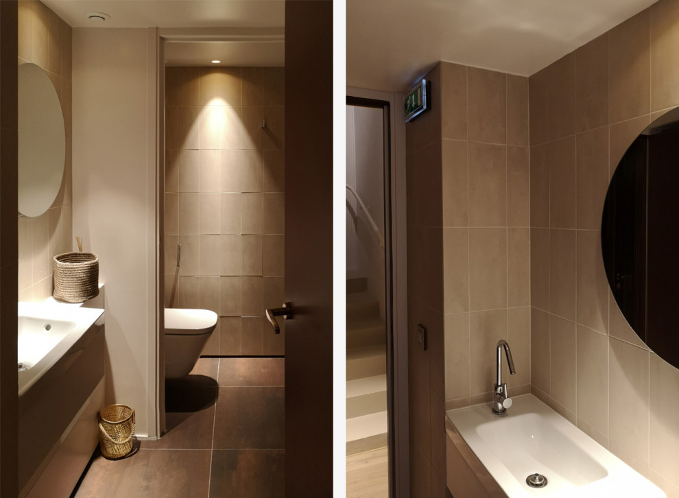 パリにある高級な小さなトランジショナルスタイルのおしゃれなトイレ・洗面所 (インセット扉のキャビネット、壁掛け式トイレ、黒いタイル、黒い壁、コンクリートの床、壁付け型シンク、グレーの床、フローティング洗面台) の写真