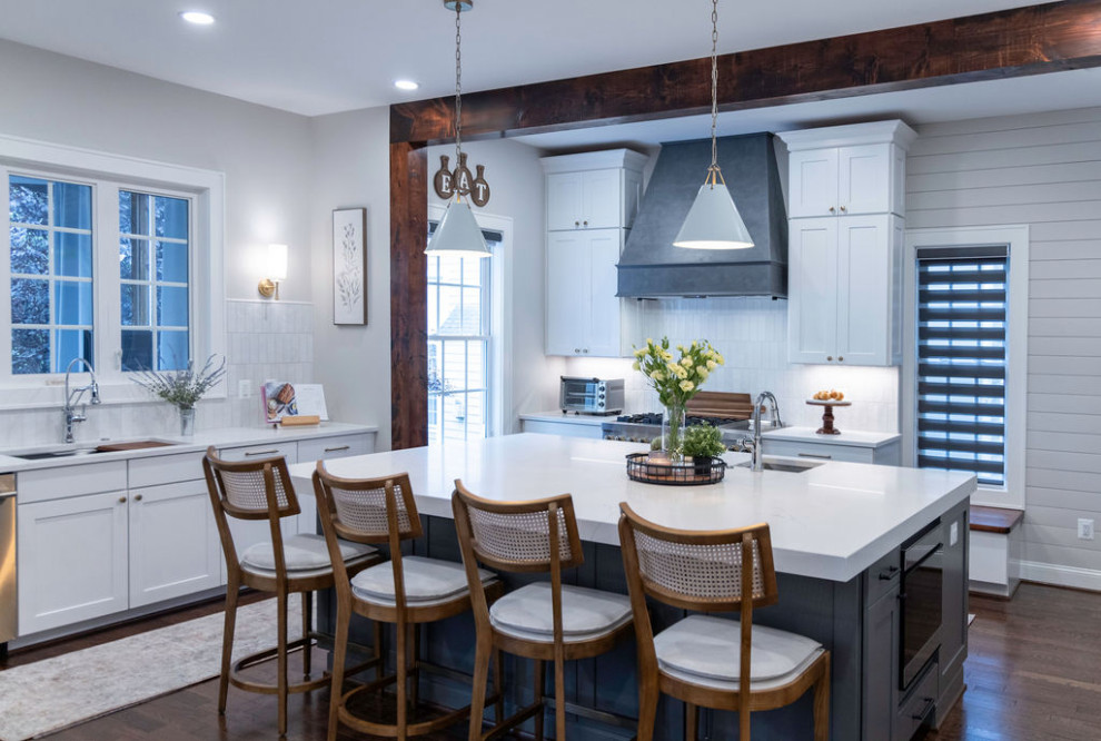 Example of a large transitional u-shaped medium tone wood floor kitchen design in DC Metro with a single-bowl sink, flat-panel cabinets, quartz countertops, white backsplash, porcelain backsplash, stainless steel appliances, an island and white countertops