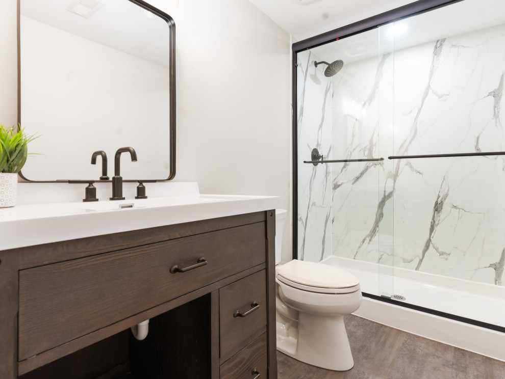 シカゴにあるビーチスタイルのおしゃれな浴室 (アルコーブ型シャワー、分離型トイレ、クッションフロア、一体型シンク、大理石の洗面台、引戸のシャワー、洗面台1つ、独立型洗面台) の写真