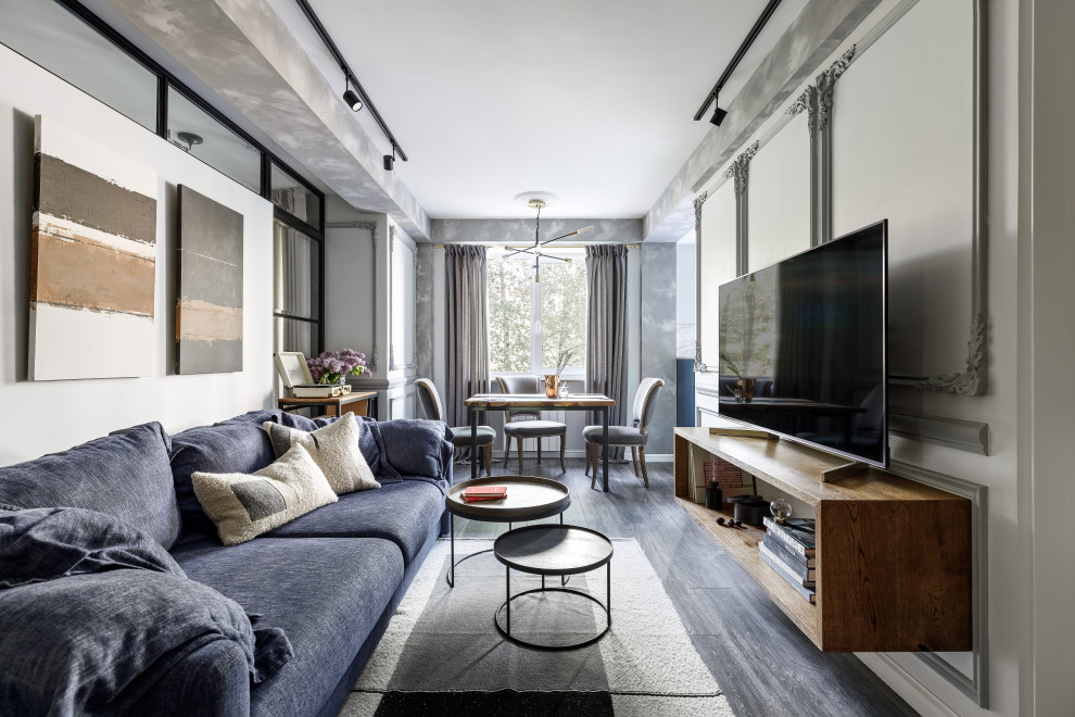 Пример оригинального дизайна: гостиная комната среднего размера в современном стиле с белыми стенами, темным паркетным полом, отдельно стоящим телевизором, черным полом и синим диваном