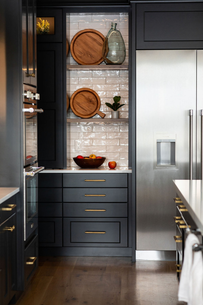 Large transitional medium tone wood floor kitchen photo in Seattle with an undermount sink, quartz countertops, white backsplash, subway tile backsplash, stainless steel appliances, an island and white countertops