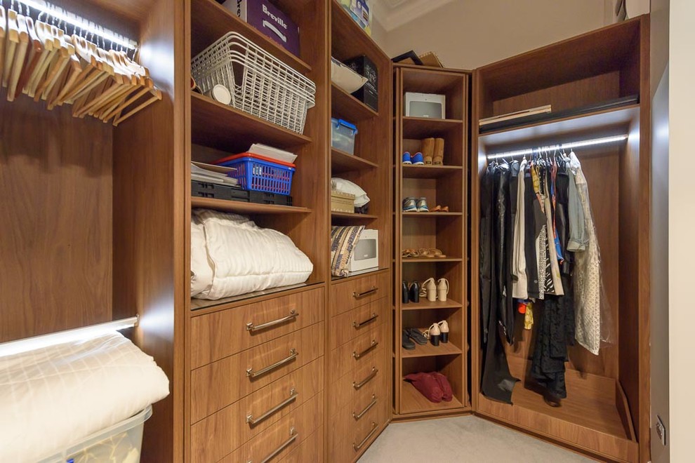 Design ideas for a large modern gender-neutral dressing room in Melbourne with flat-panel cabinets, medium wood cabinets, carpet and grey floor.