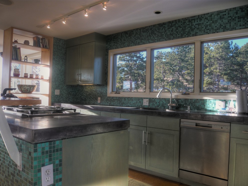 Small contemporary l-shaped open plan kitchen in Denver with recessed-panel cabinets, green cabinets, concrete benchtops, blue splashback, glass tile splashback, stainless steel appliances, cork floors and with island.