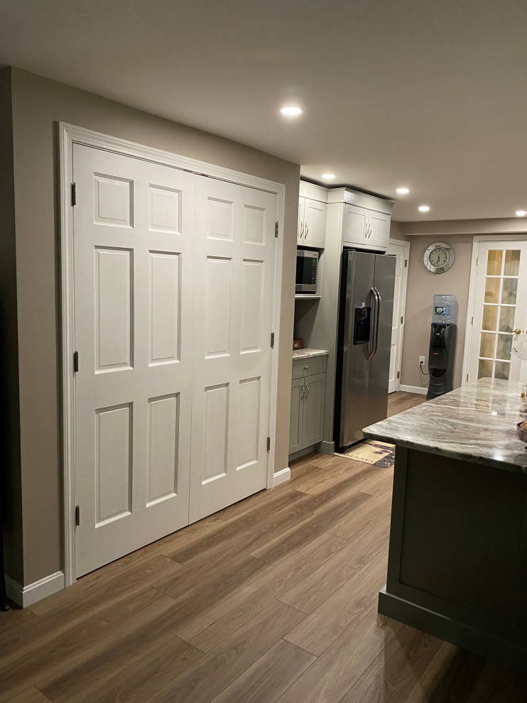 Mid-sized transitional u-shaped vinyl floor and brown floor eat-in kitchen photo in Boston with an undermount sink, recessed-panel cabinets, gray cabinets, granite countertops, beige backsplash, ceramic backsplash, stainless steel appliances, a peninsula and multicolored countertops