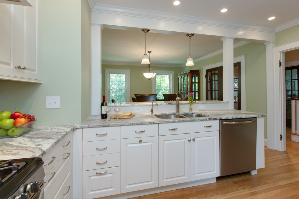Example of a transitional u-shaped medium tone wood floor eat-in kitchen design in Boston with an undermount sink, raised-panel cabinets, white cabinets, granite countertops, white backsplash, subway tile backsplash and stainless steel appliances