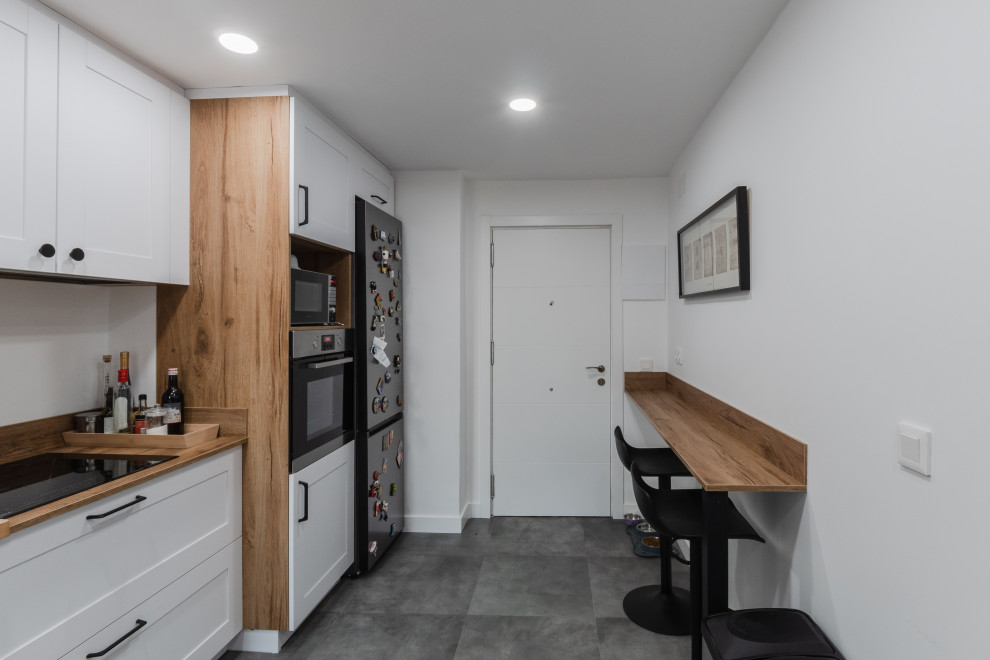 Foto de cocinas en L blanca y madera actual grande cerrada con fregadero encastrado, armarios con rebordes decorativos, puertas de armario blancas, encimera de madera, salpicadero marrón, salpicadero de madera, electrodomésticos de acero inoxidable, suelo de baldosas de porcelana, suelo gris y encimeras marrones