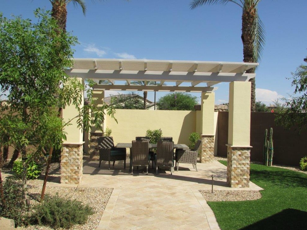Photo of a mid-sized mediterranean backyard patio in Phoenix with a fire feature, natural stone pavers and a pergola.