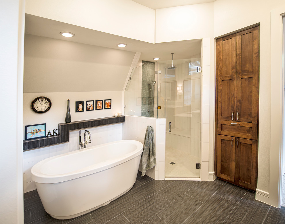 Photo of a transitional master bathroom in Austin with a freestanding tub, a corner shower, gray tile, ceramic floors and beige walls.