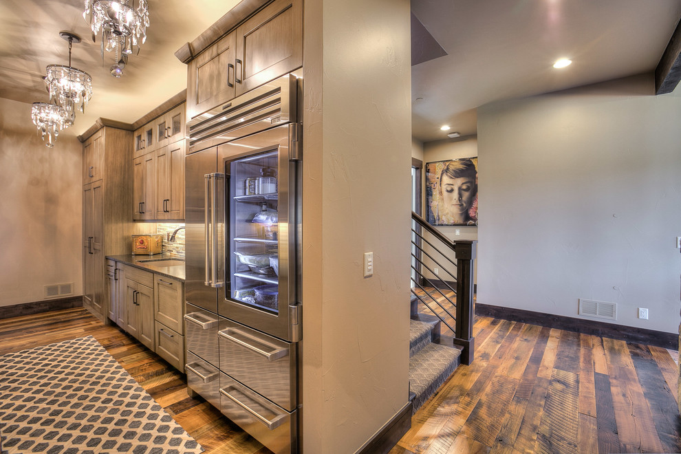 Huge mountain style l-shaped medium tone wood floor eat-in kitchen photo in Denver with an undermount sink, shaker cabinets, medium tone wood cabinets, granite countertops, beige backsplash, stone tile backsplash, stainless steel appliances and two islands