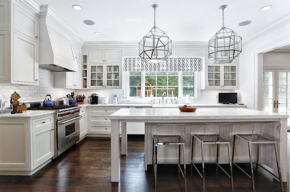 This is an example of a traditional kitchen in New York with a farmhouse sink, recessed-panel cabinets, white cabinets, white splashback, subway tile splashback and stainless steel appliances.