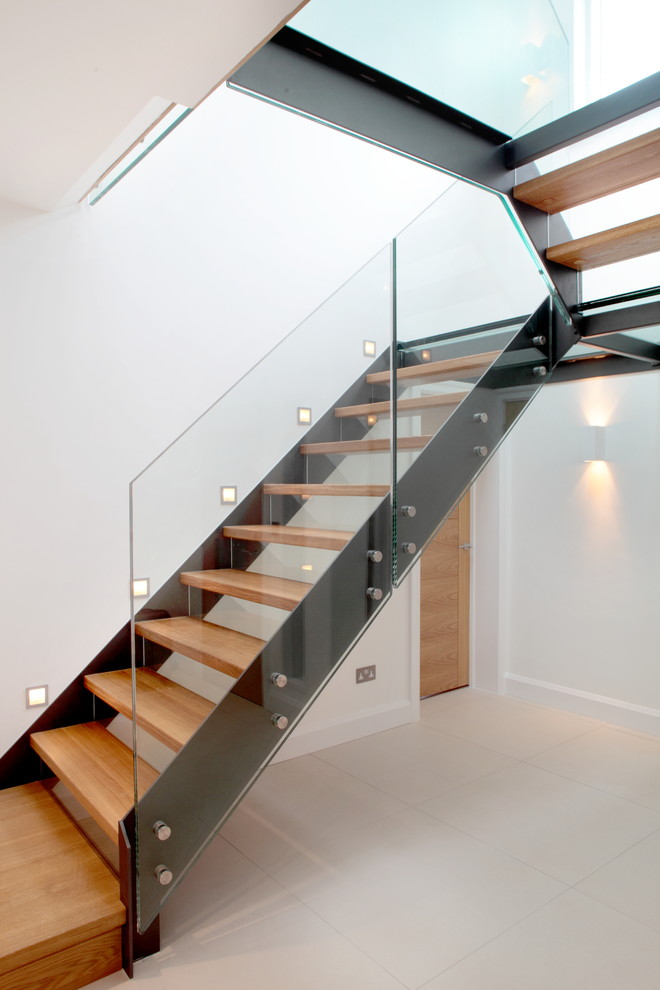 Photo of a mid-sized contemporary wood u-shaped staircase in Buckinghamshire with open risers.