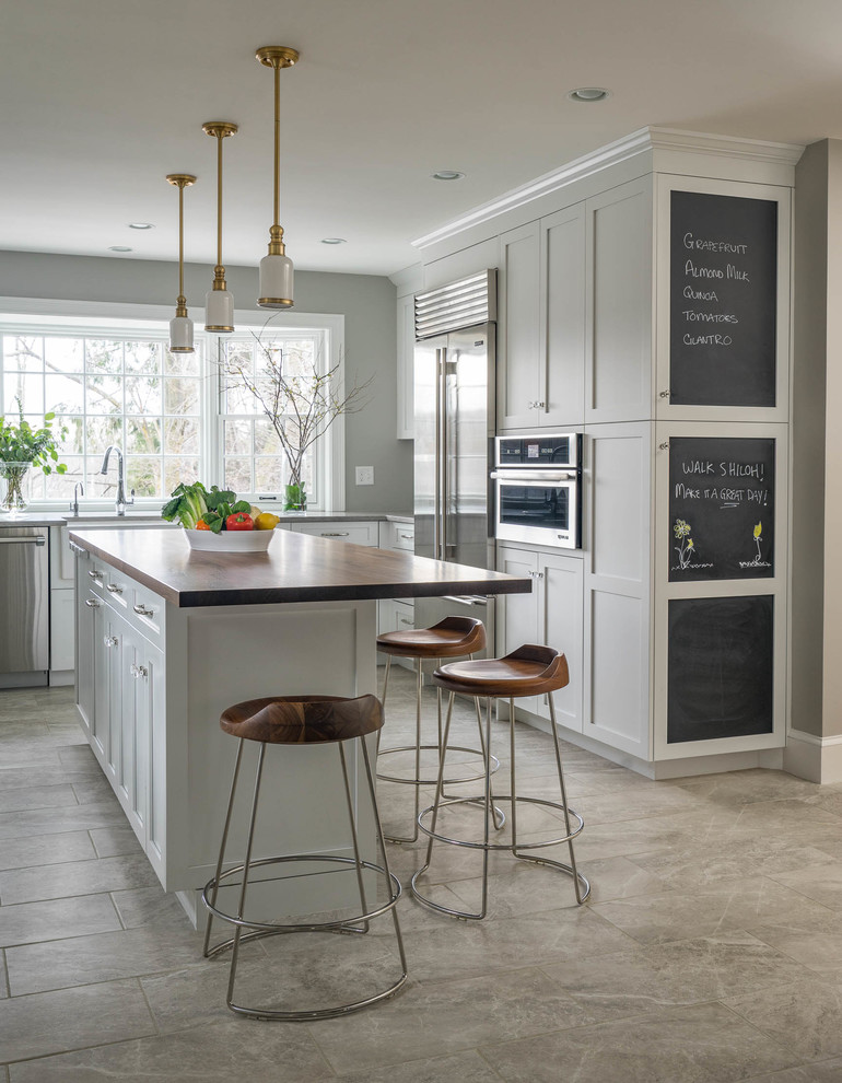 This is an example of a large traditional kitchen in Boston with stainless steel appliances, with island, shaker cabinets, grey cabinets and grey floor.