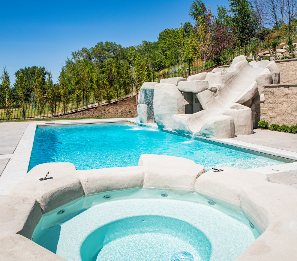 Immagine di una grande piscina monocorsia tradizionale dietro casa con una vasca idromassaggio