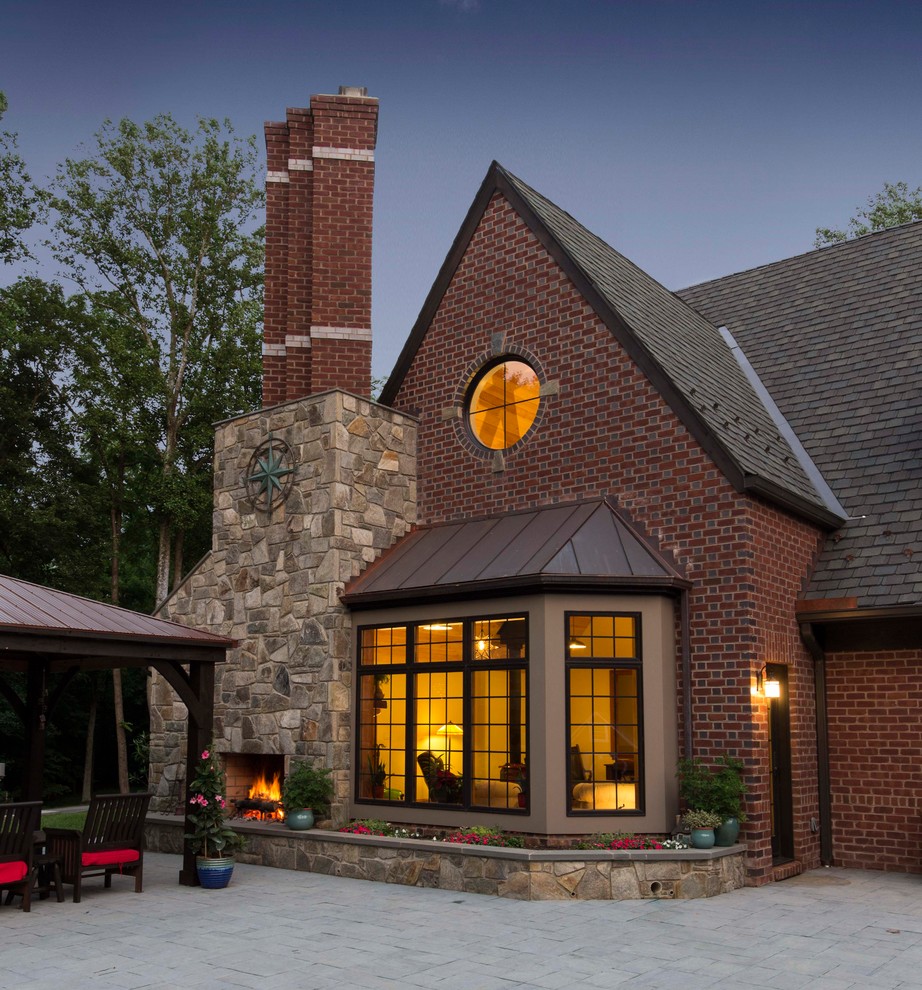 Photo of a large traditional two-storey brick red house exterior in DC Metro with a hip roof and a shingle roof.