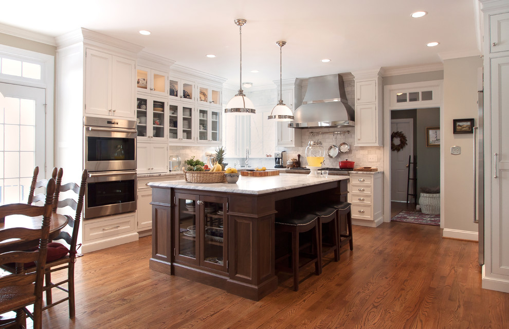 Transitional u-shaped kitchen photo in DC Metro with beaded inset cabinets, dark wood cabinets, marble countertops, white backsplash, stainless steel appliances and an island
