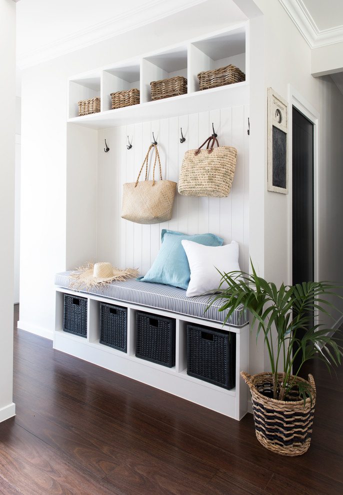 Design ideas for a small beach style mudroom in Gold Coast - Tweed with dark hardwood floors and white walls.