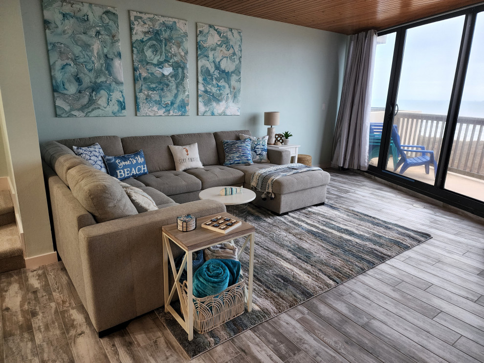 Esempio di un soggiorno costiero di medie dimensioni e aperto con pareti blu, pavimento in gres porcellanato, nessun camino, TV a parete, pavimento grigio e soffitto in perlinato