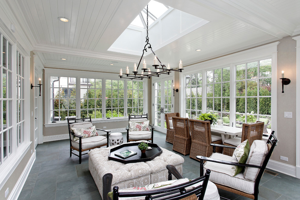 This is an example of a traditional sunroom in Chicago with a skylight and grey floor.