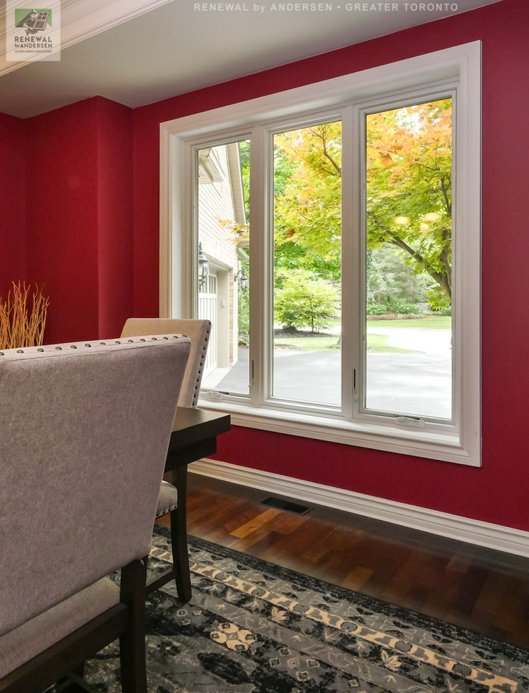 This is an example of a mid-sized separate dining room in Toronto with red walls, dark hardwood floors, no fireplace, multi-coloured floor and coffered.