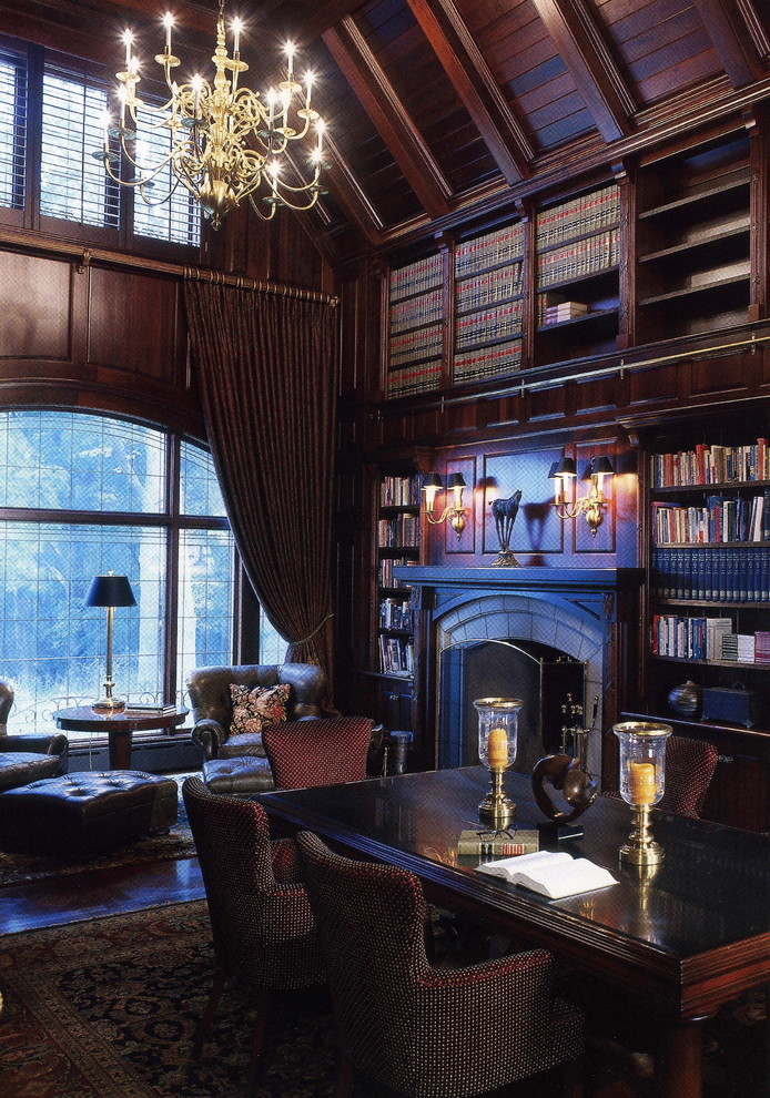 This is an example of a traditional family room in New York with a library, brown walls, a standard fireplace and no tv.