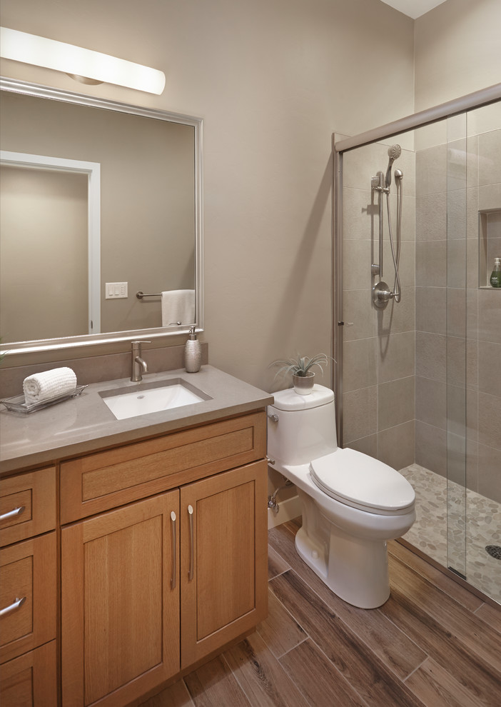 Design ideas for a small transitional 3/4 bathroom in Phoenix with recessed-panel cabinets, an alcove shower, a one-piece toilet, pebble tile and an undermount sink.