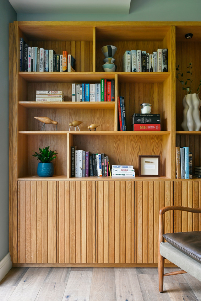 Foto di un grande studio scandinavo con libreria, pareti blu, pavimento in legno massello medio, scrivania autoportante e pavimento marrone