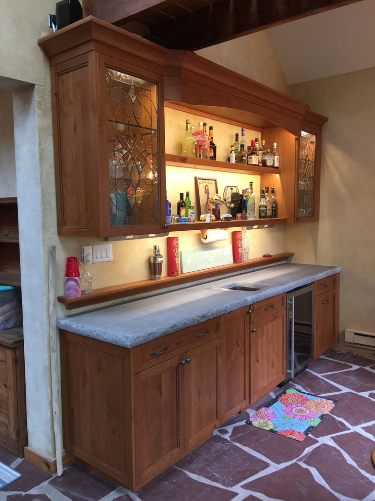 Photo of a mid-sized country galley wet bar in New York with an undermount sink, shaker cabinets, concrete benchtops, multi-coloured splashback, slate floors and medium wood cabinets.