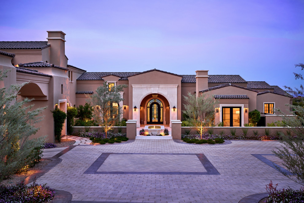 Photo of an expansive mediterranean two floor detached house in Phoenix with stone cladding and a tiled roof.