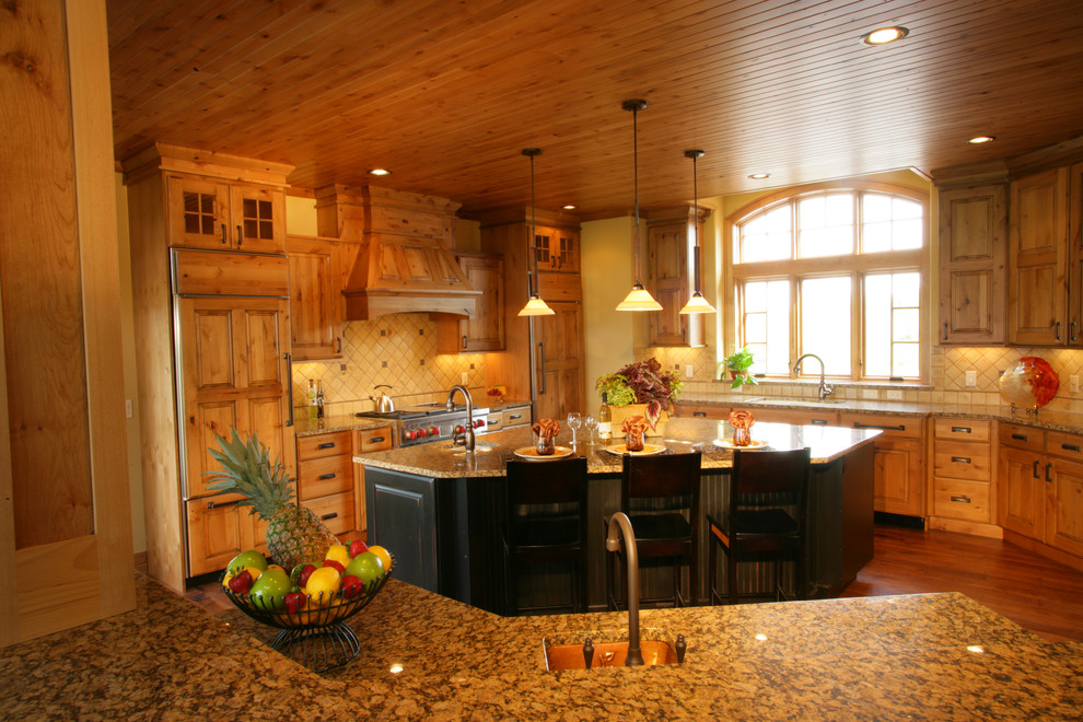 Eat-in kitchen - large rustic u-shaped dark wood floor and brown floor eat-in kitchen idea with an undermount sink, raised-panel cabinets, dark wood cabinets, granite countertops, white backsplash, ceramic backsplash, paneled appliances and two islands