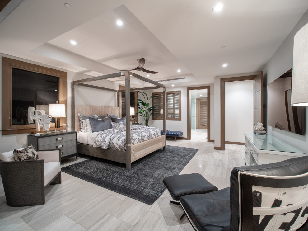 This is an example of a large contemporary master bedroom in Hawaii with white walls, travertine floors, beige floor and coffered.