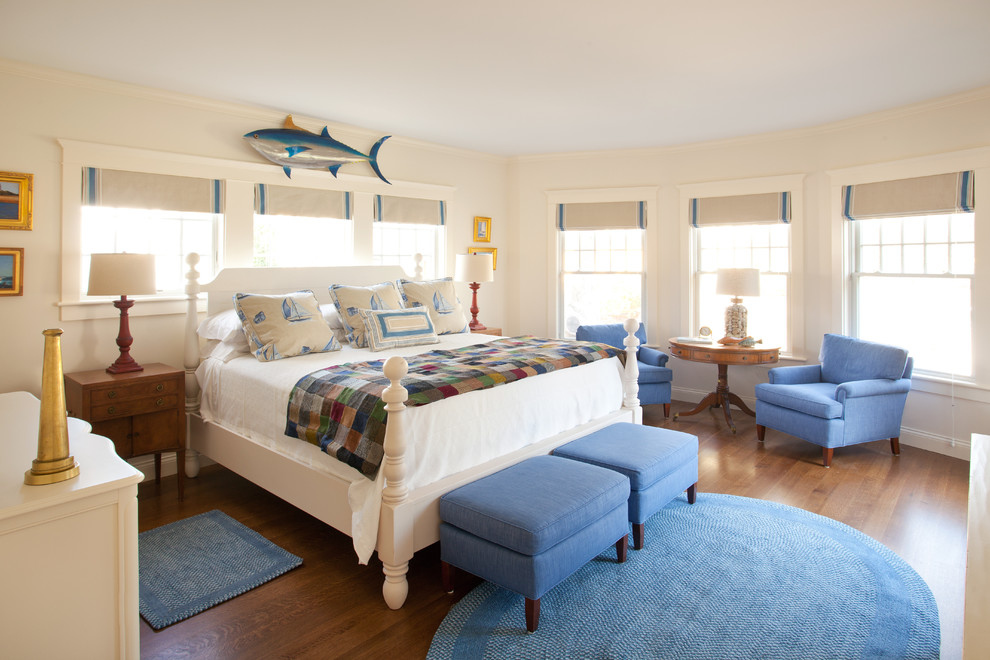 Large beach style master bedroom in Boston with white walls, medium hardwood floors and no fireplace.