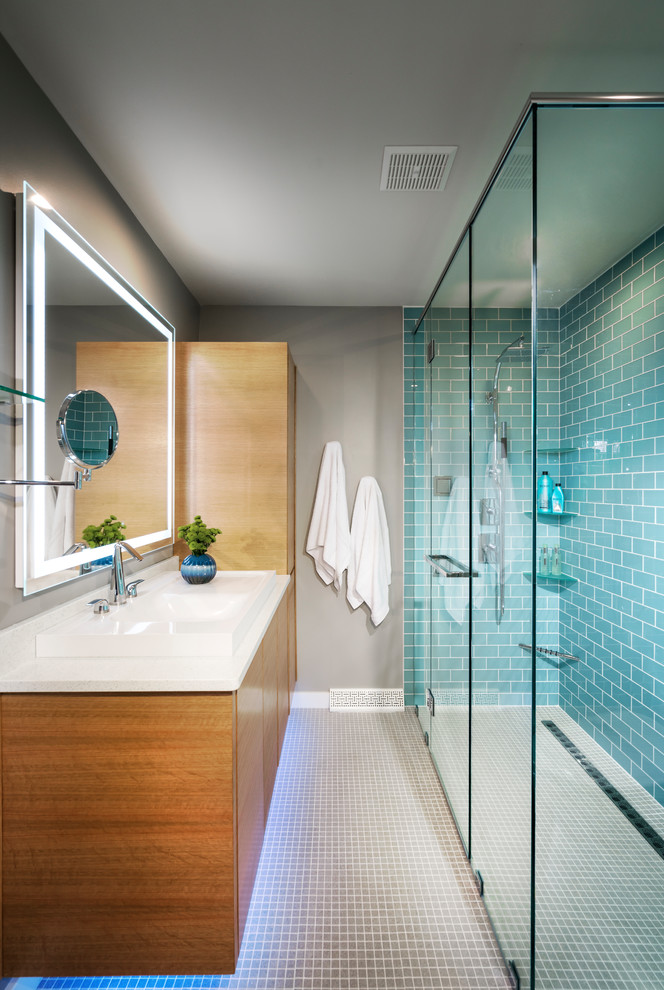 Inspiration for a mid-sized midcentury master bathroom in Other with flat-panel cabinets, light wood cabinets, a corner shower, a one-piece toilet, blue tile, subway tile, blue walls, a drop-in sink, quartzite benchtops, grey floor, a hinged shower door and white benchtops.