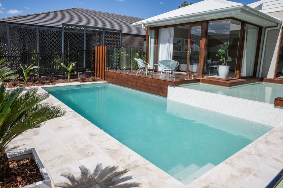 Mid-sized contemporary backyard rectangular lap pool in Sydney with natural stone pavers.