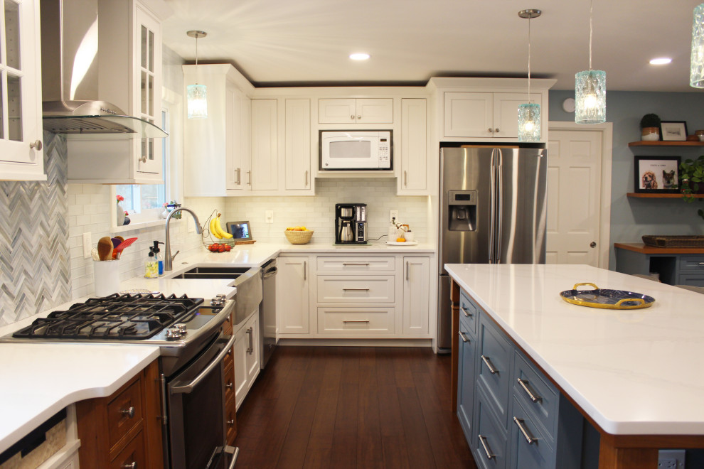 Modern inredning av ett avskilt, mellanstort vit vitt u-kök, med en rustik diskho, luckor med profilerade fronter, vita skåp, bänkskiva i kvartsit, vitt stänkskydd, stänkskydd i glaskakel, rostfria vitvaror, bambugolv, en köksö och brunt golv