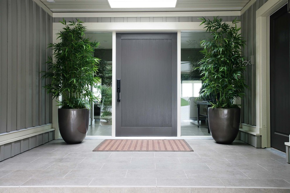 Inspiration for a mid-sized modern front door in Vancouver with grey walls, ceramic floors, a single front door and a gray front door.