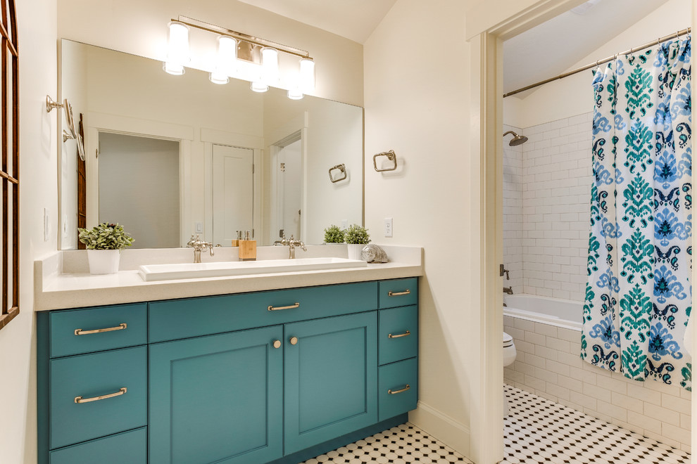 Mid-sized traditional 3/4 bathroom in Salt Lake City with recessed-panel cabinets, turquoise cabinets, a drop-in tub, a shower/bathtub combo, a two-piece toilet, white tile, ceramic tile, white walls, ceramic floors, a trough sink, granite benchtops, multi-coloured floor and a shower curtain.