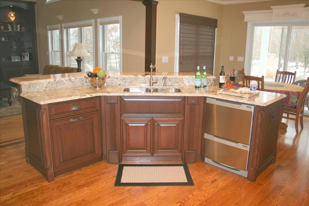 Transitional medium tone wood floor enclosed kitchen photo in St Louis with a double-bowl sink, dark wood cabinets, granite countertops, stainless steel appliances and an island