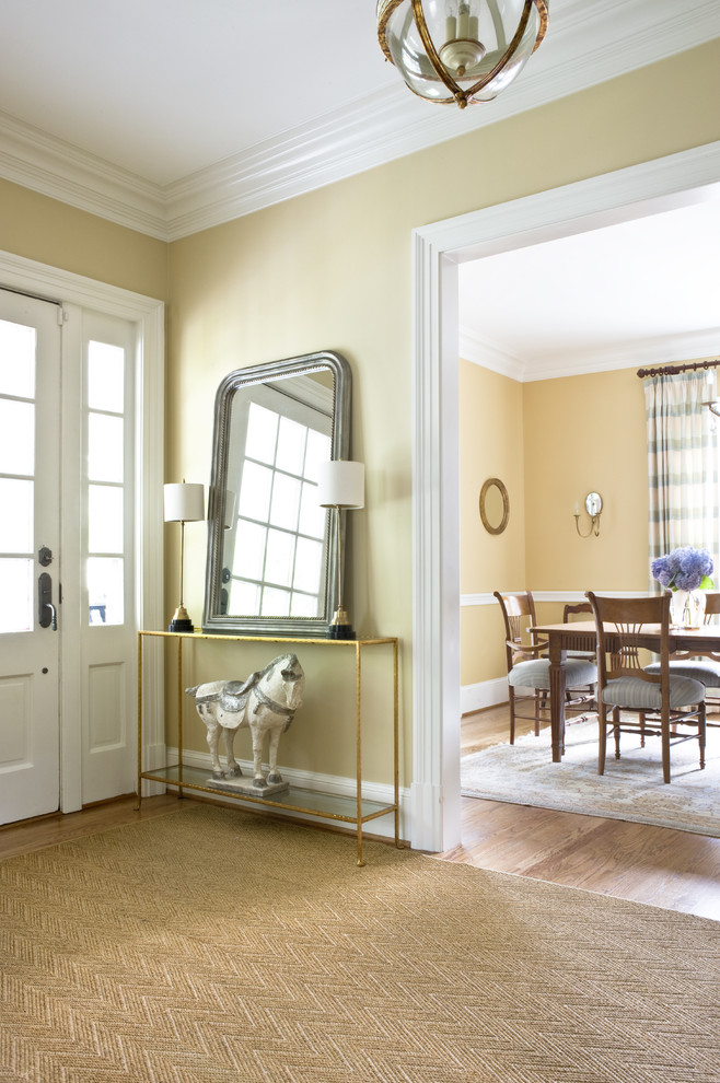Inspiration for a mid-sized traditional foyer in DC Metro with a single front door, yellow walls, light hardwood floors and a white front door.
